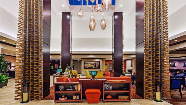 A spacious lobby with a central seating area, a large chandelier, and a modern design.