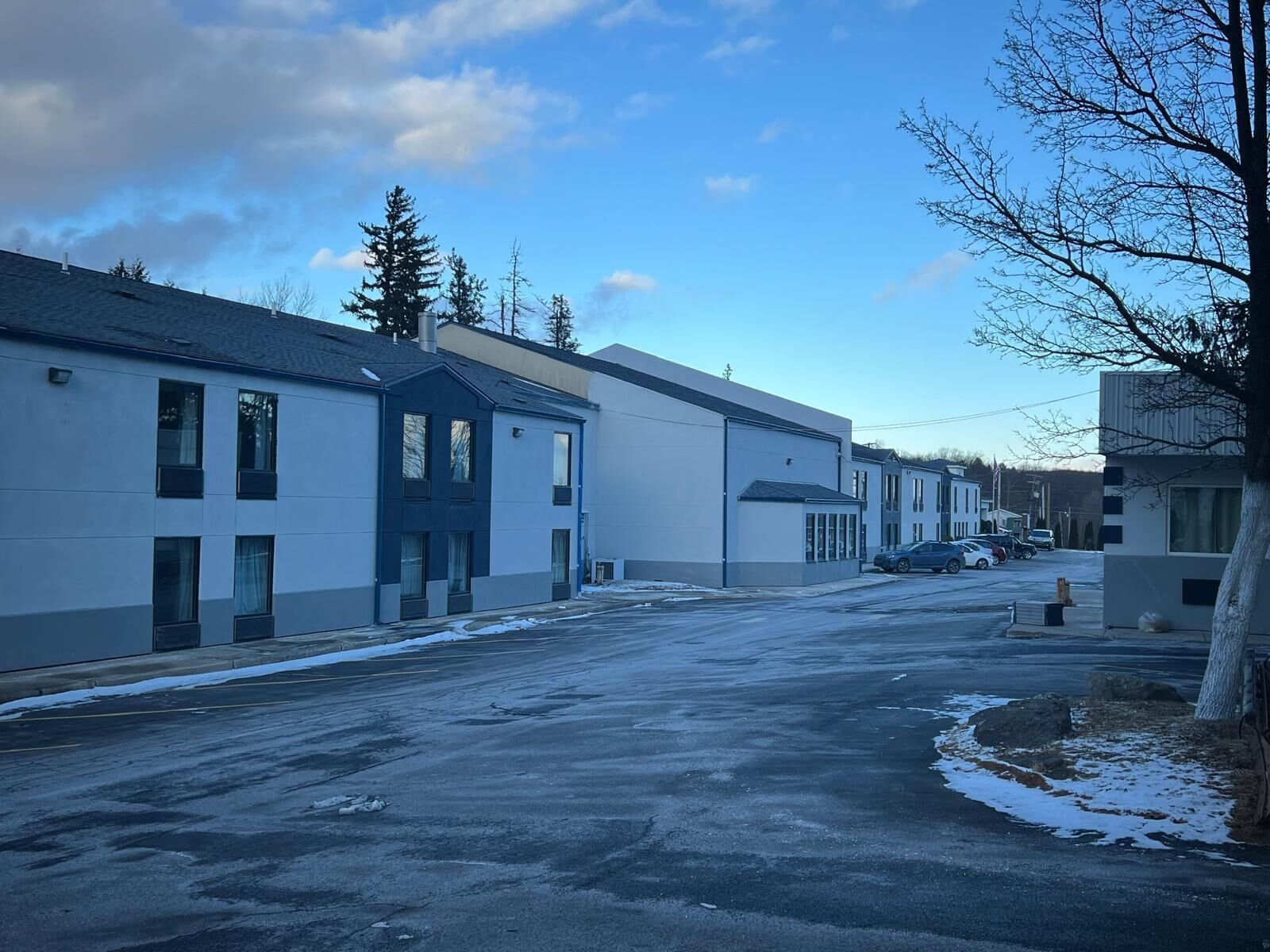 Une vue de rue avec des bâtiments, un parking et un ciel dégagé.