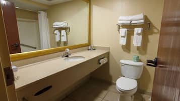 A bathroom with a sink, mirror, toilet, and towel rack.