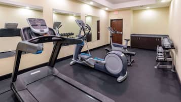 A gym with treadmills, elliptical machines, and free weights.