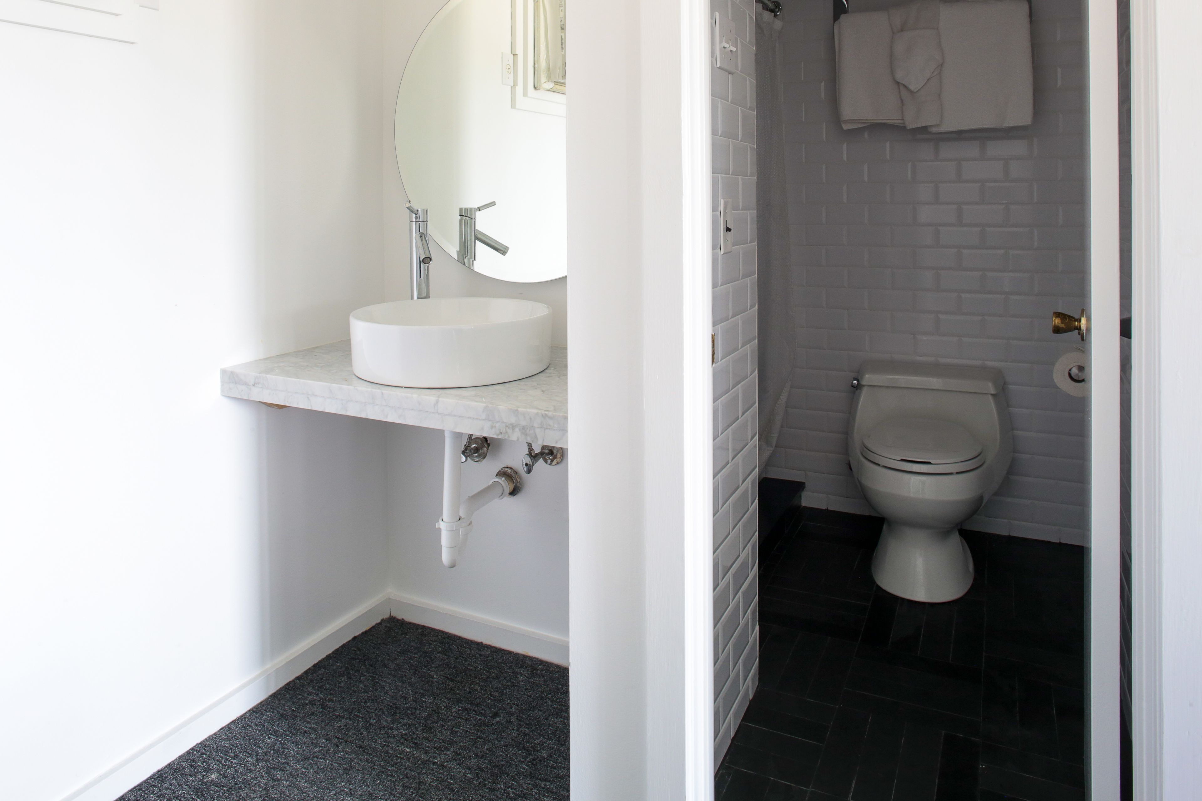 Ein Badezimmer mit Waschbecken, Spiegel und Toilette.