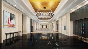 A long, polished hallway with a central chandelier, marble walls, and a reflective floor. - Crowne Plaza Chengdu West by IHG (Chengdu)