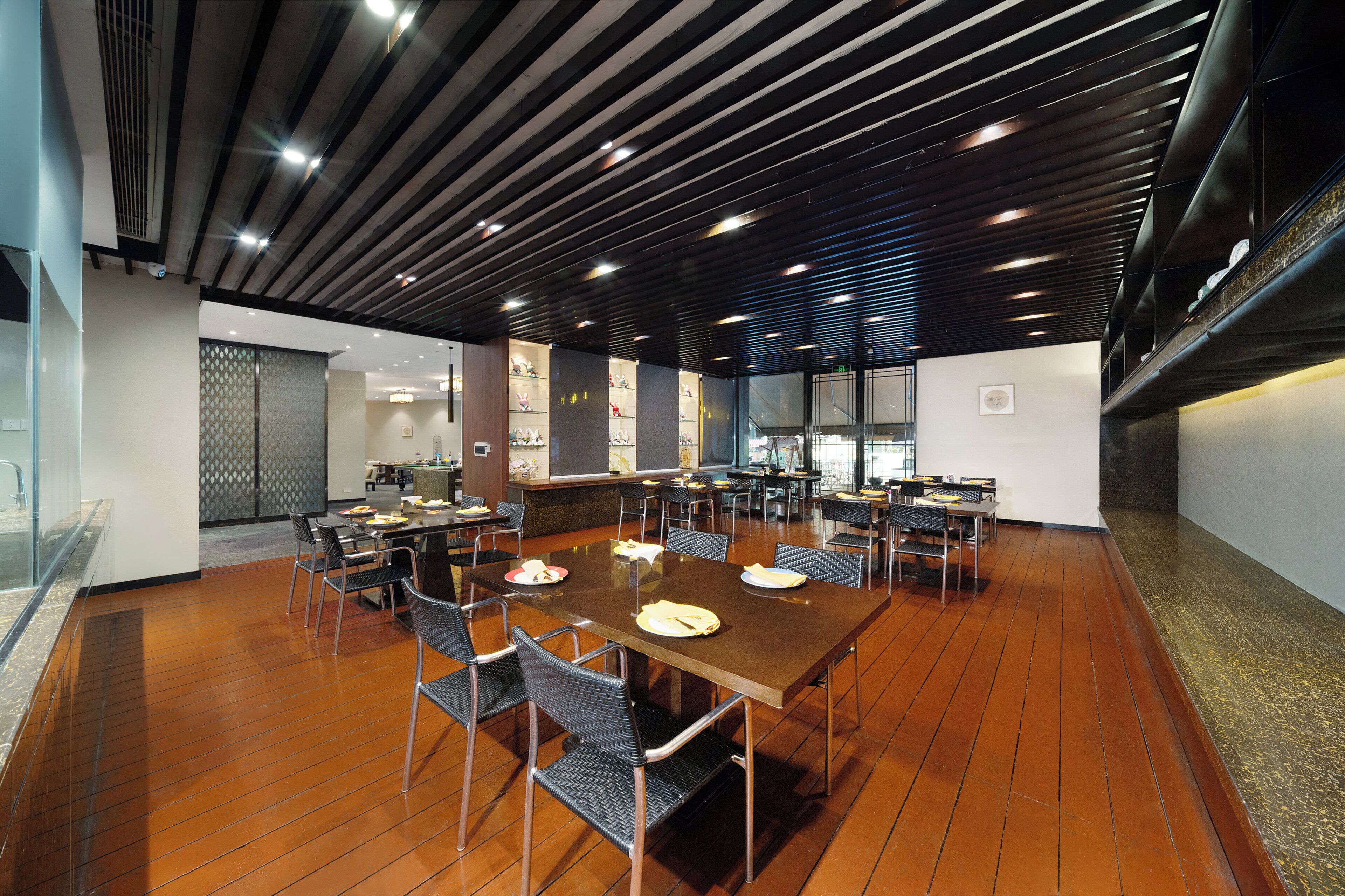 Un salón de conferencias con una larga mesa, sillas y una zona de bar.