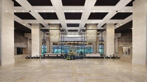 A spacious lobby with a high ceiling, large windows, and a central seating area with a floral arrangement. - Crowne Plaza Chengdu West by IHG (Chengdu)