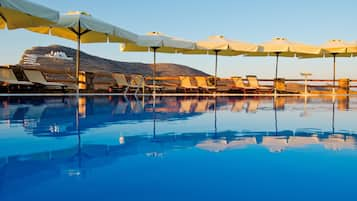 Una piscina al aire libre de temporada, sombrillas