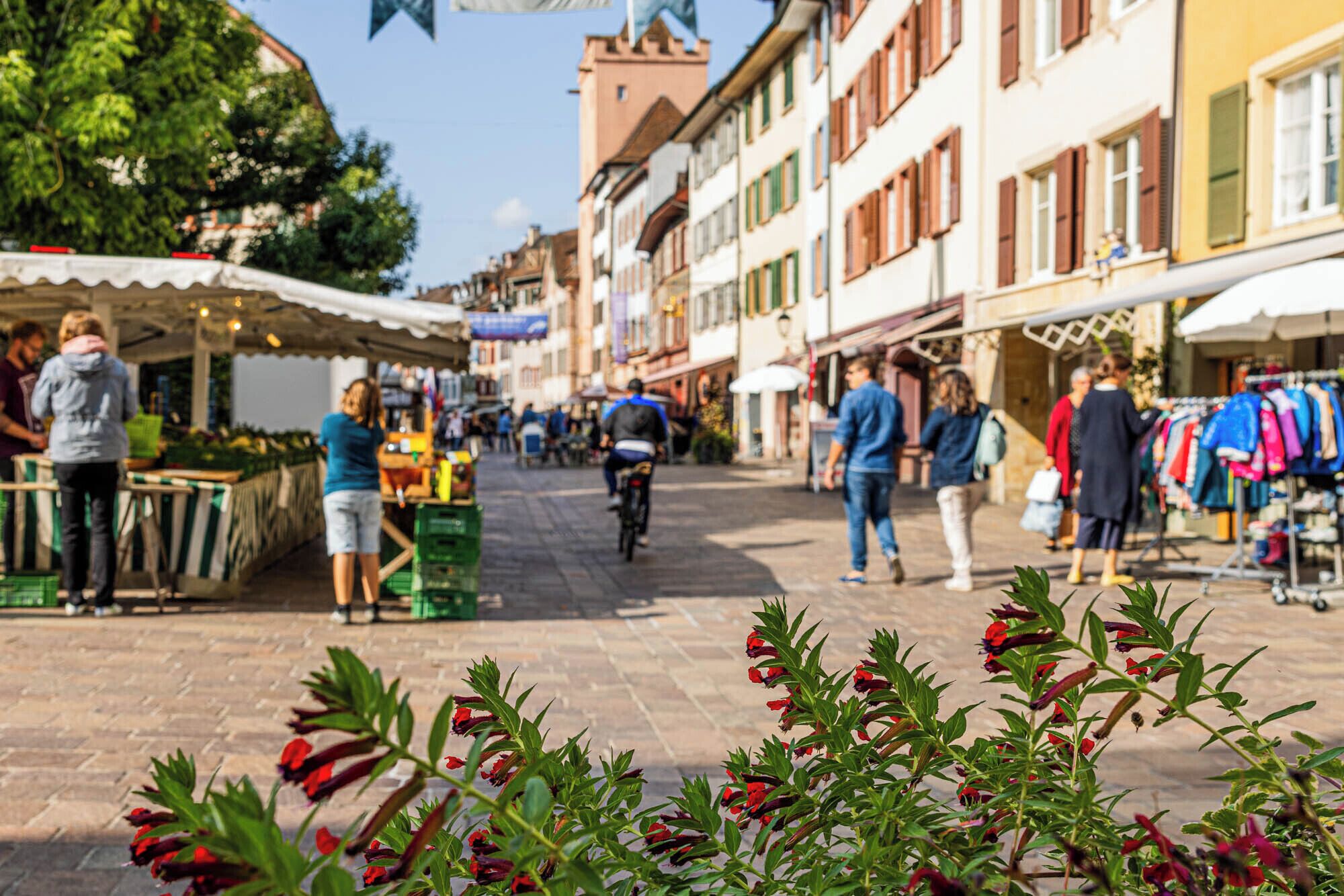 A bustling street market with vendors and shoppers.