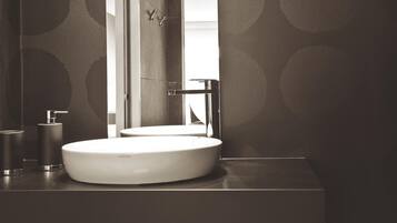 Une salle de bain moderne avec un lavabo rond, un miroir et un robinet.
