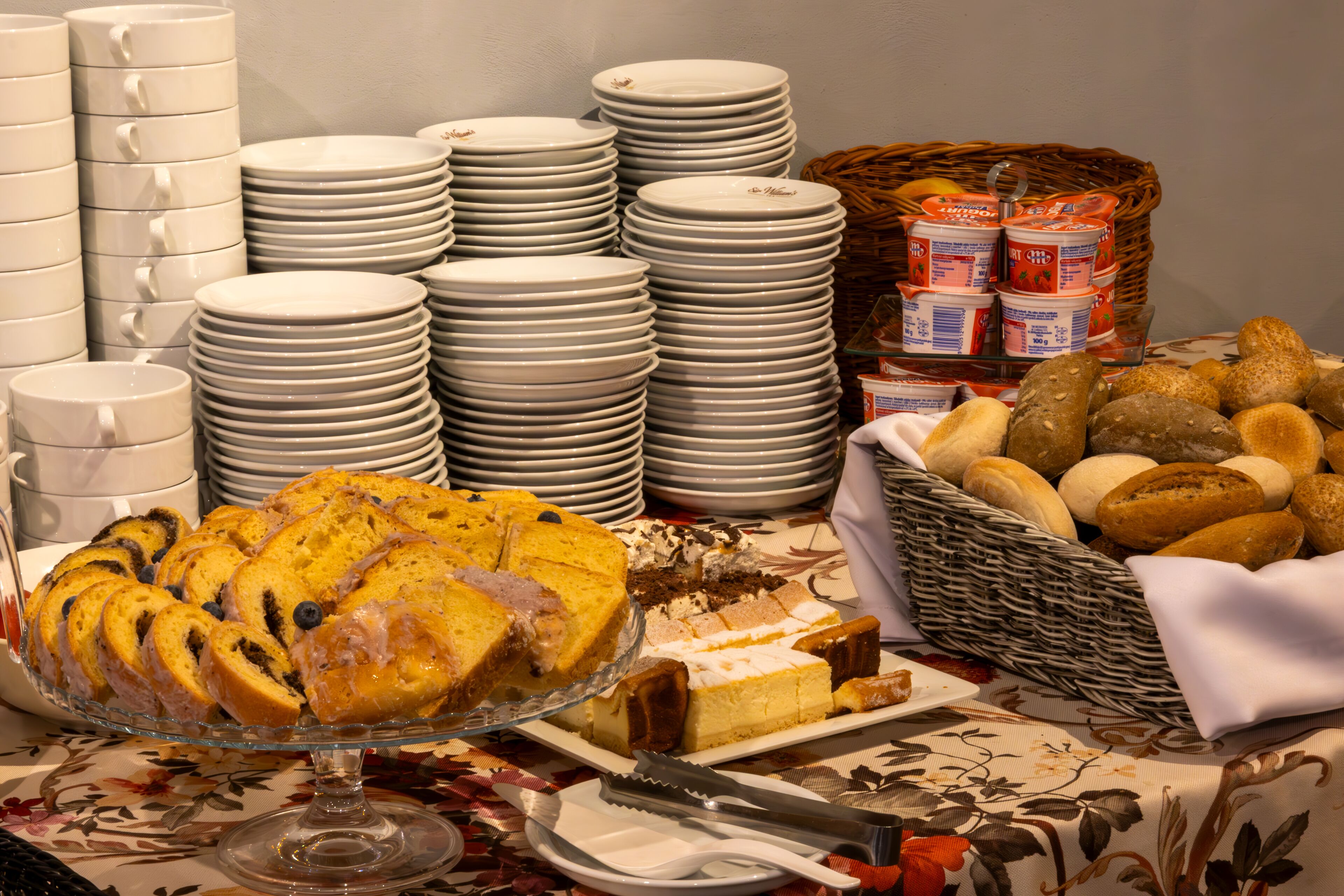Ein reichhaltiges Buffet mit verschiedenen Speisen, darunter eine große Torte, Brot und Beilagen.