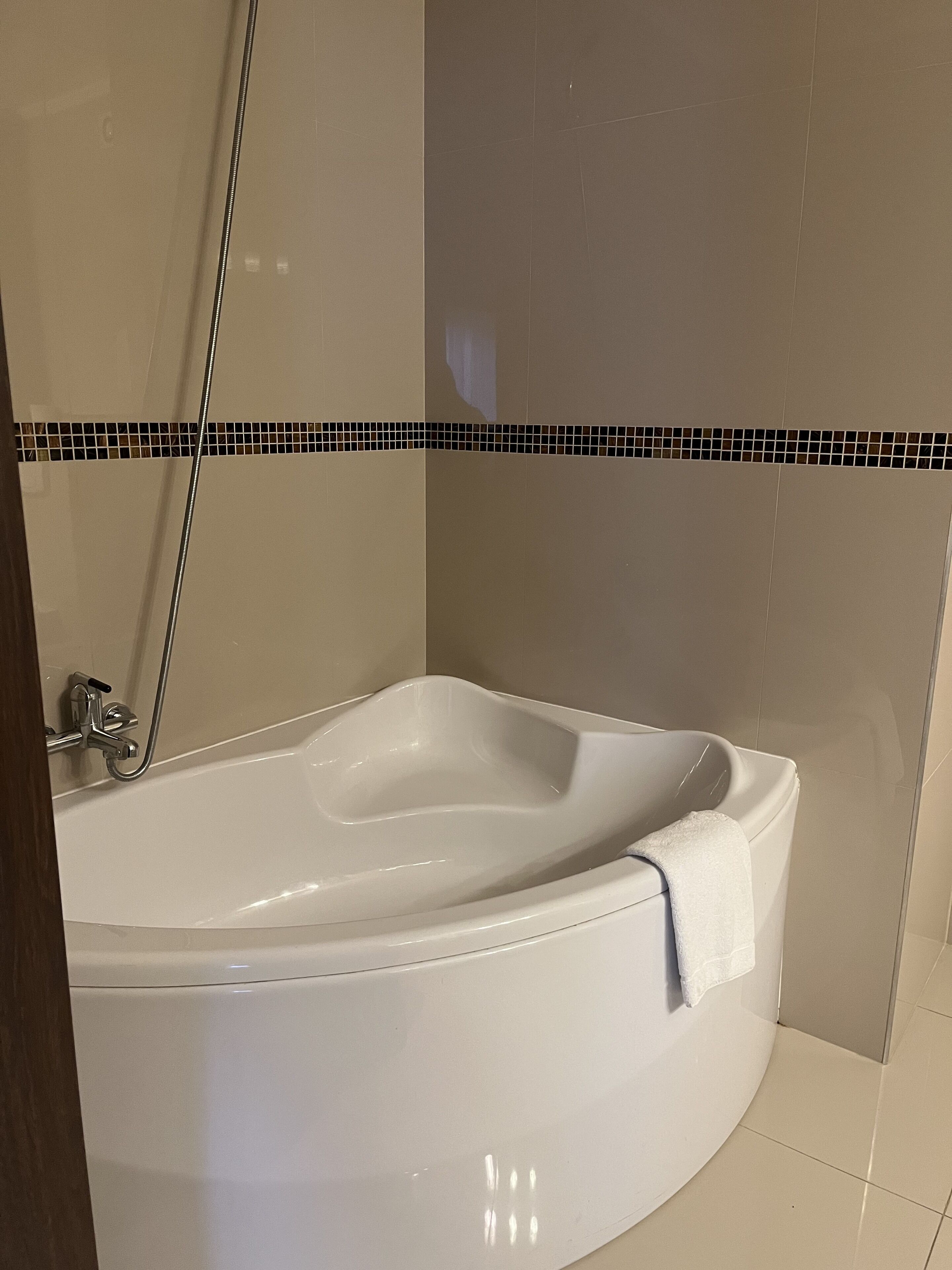 A modern bathroom with a freestanding bathtub, a shower area, and a tiled floor.