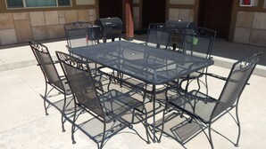 A metal table and chairs set outdoors with a fire extinguisher on the wall. - Winterton Suites (Williston)