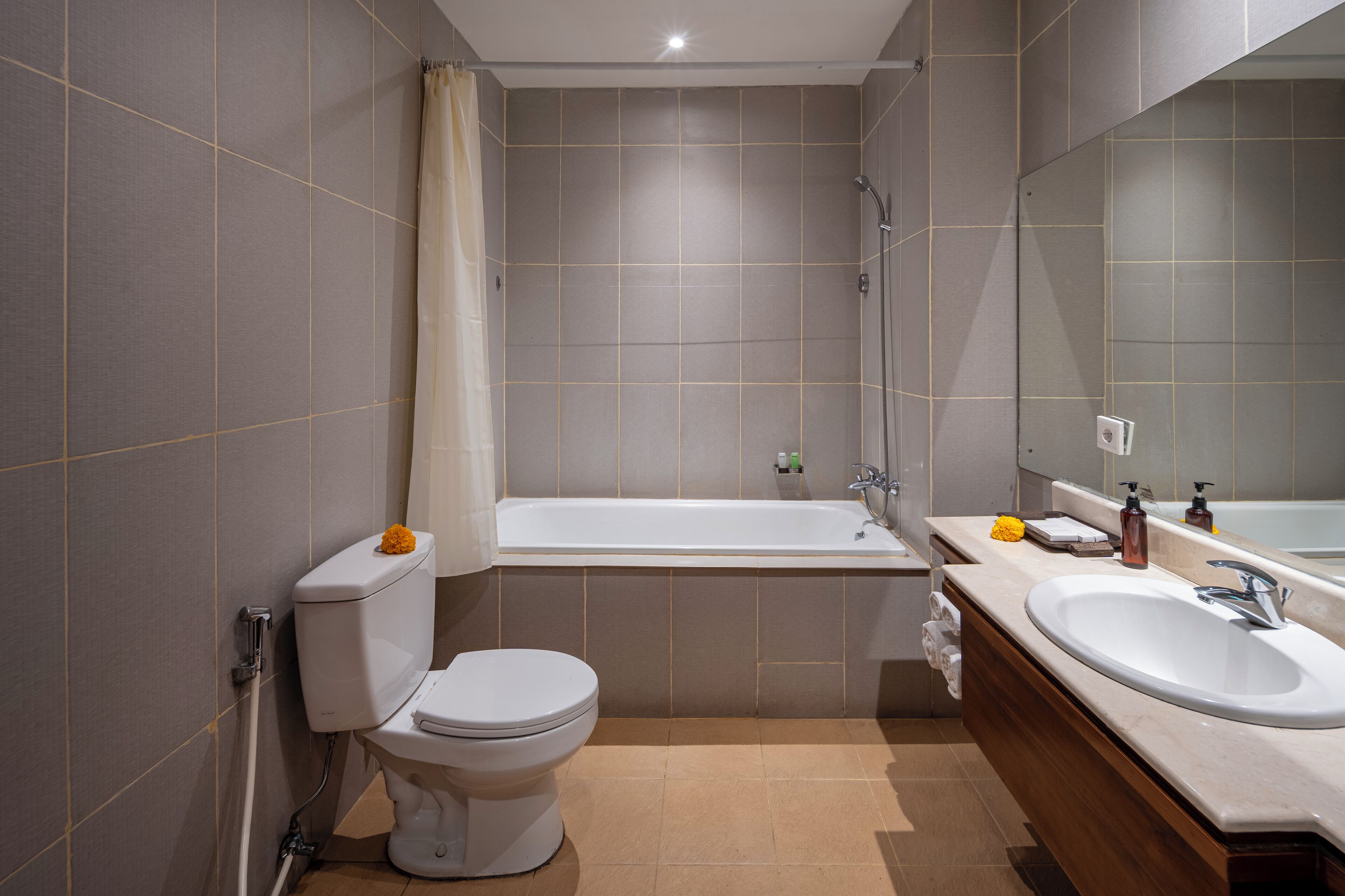 Un baño moderno con inodoro, bañera y dos lavabos.