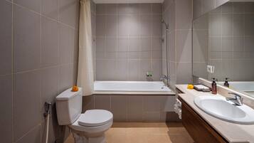 Un baño moderno con inodoro, bañera y dos lavabos.