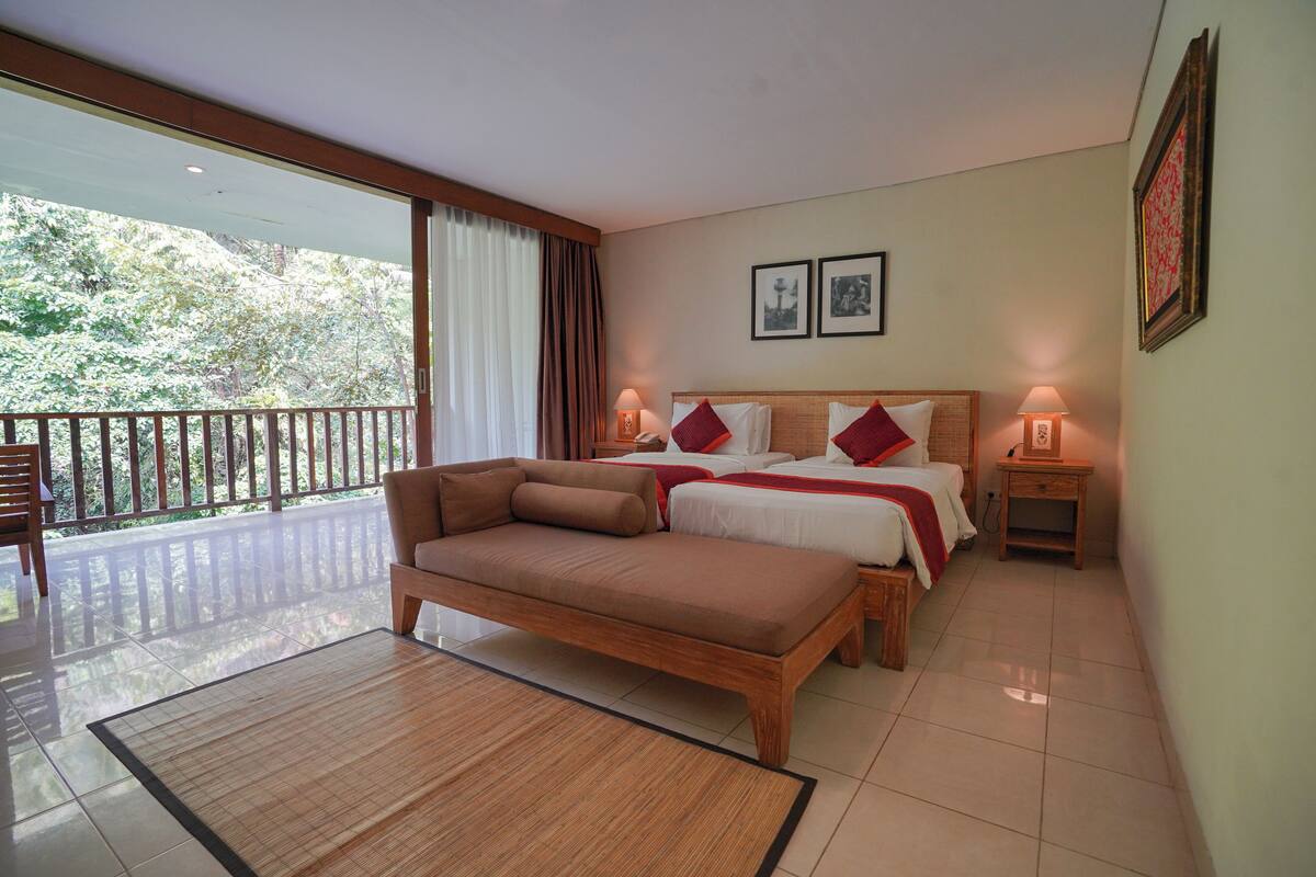 Une chambre avec un grand lit, un canapé, un balcon et deux lampes de chevet.