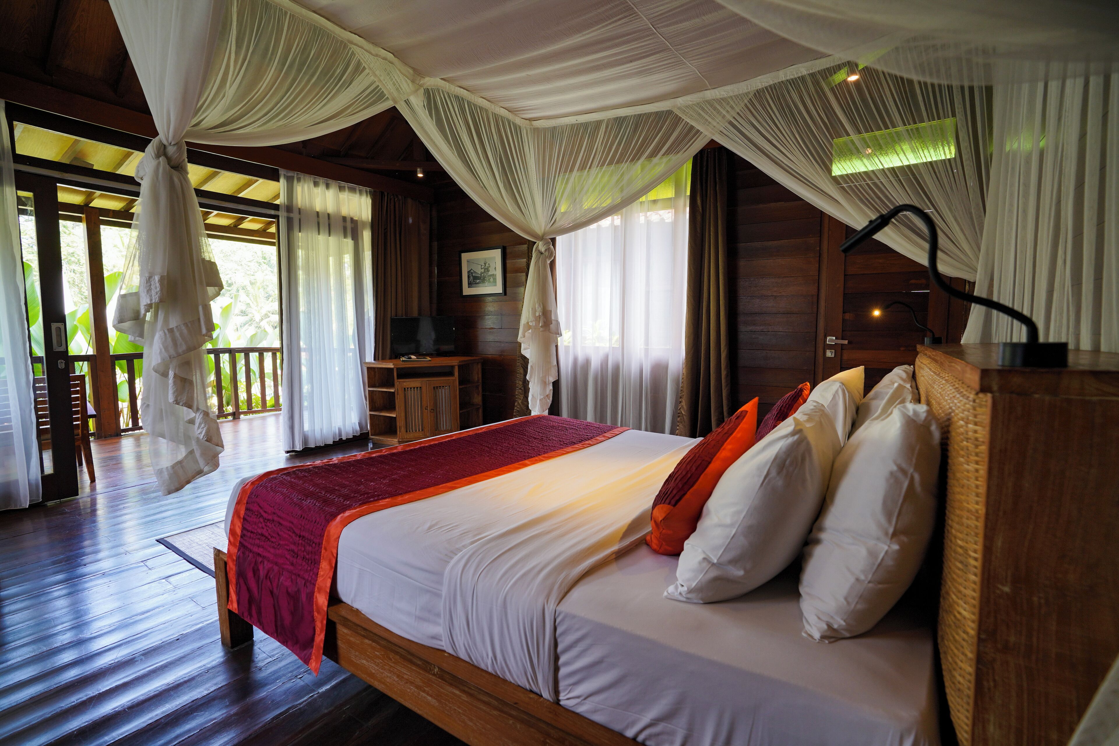 A spacious bedroom with a large bed, wooden headboard, and a canopy.