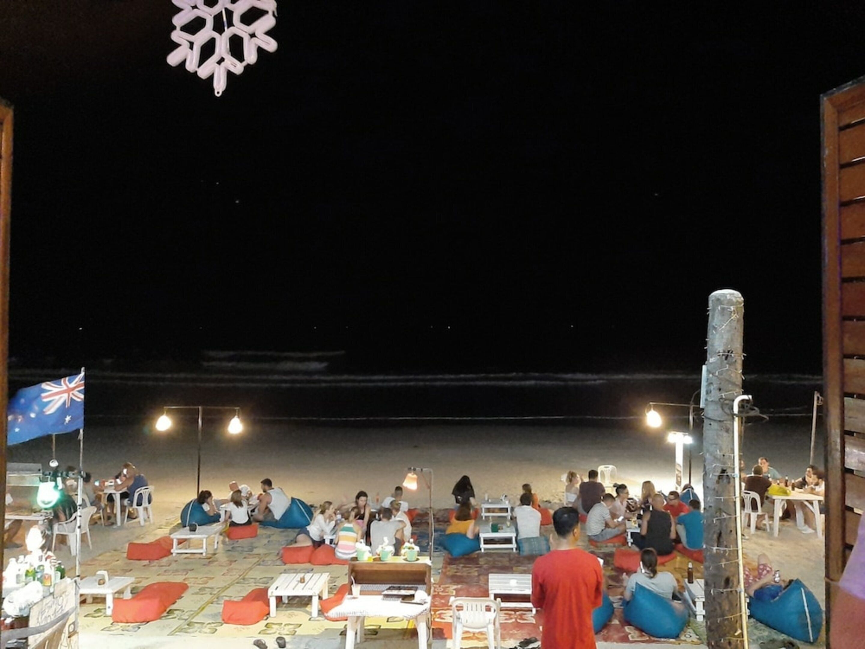 Un espacio al aire libre con mesas y sillas, una bandera y un copo de nieve decorativo.