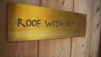 A wooden sign with the text "ROOF WITH A VIEW".