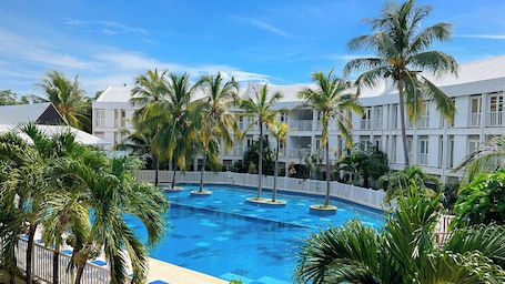 Una piscina al aire libre, sombrillas, sillones reclinables de piscina