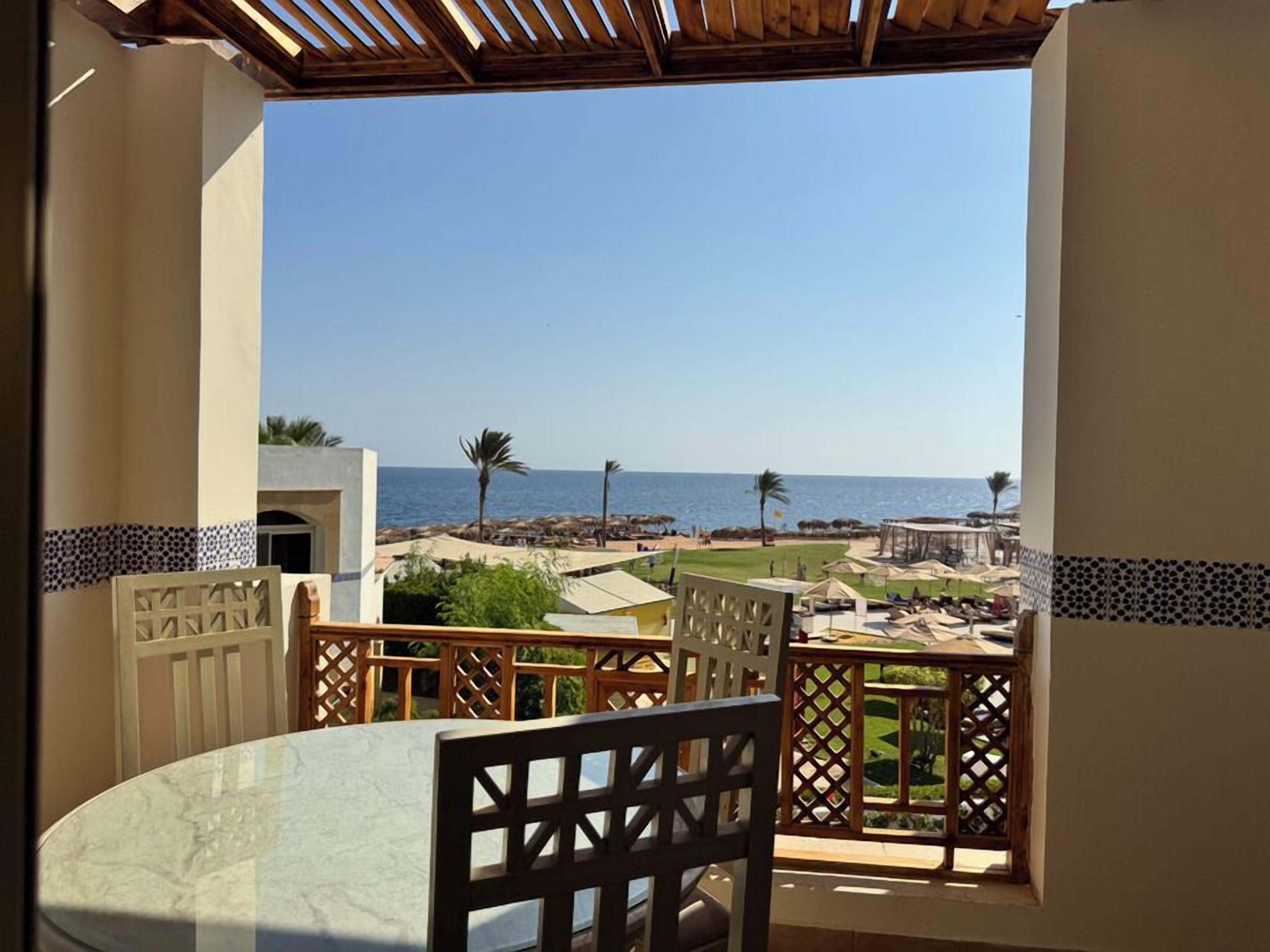Un balcon avec vue sur la mer, une table et des chaises.