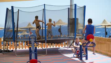 Une aire de jeux équipée d’un trampoline et d’appareils de musculation.