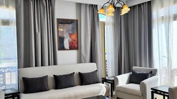 Ein modernes Wohnzimmer mit einer Couch, Sesseln, einem Couchtisch und einem Kronleuchter.
