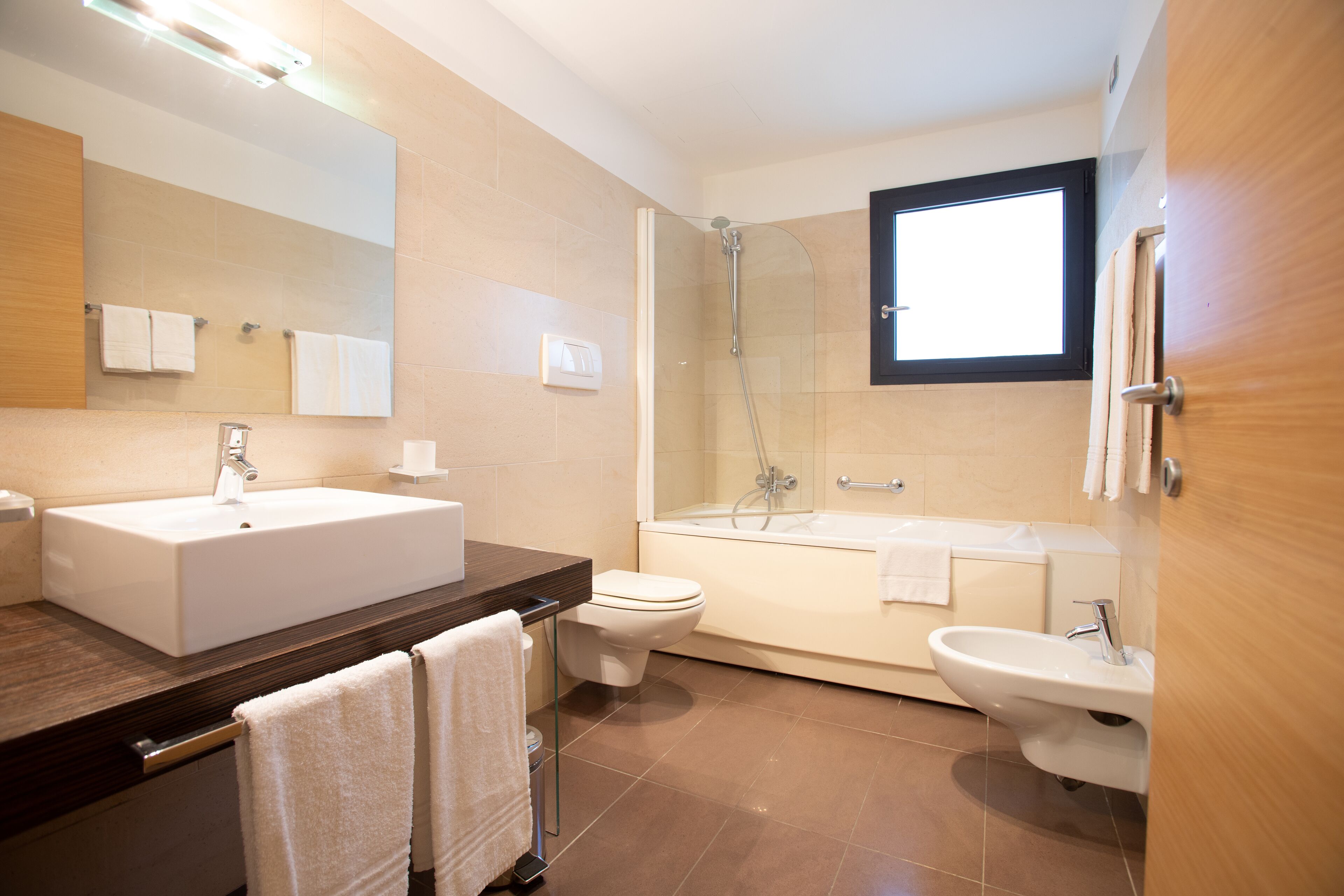 Un bagno moderno con un lavandino capiente, il water, una doccia e una vasca.