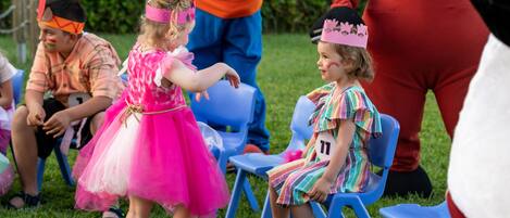 Un grupo de niños y adultos disfrazados en un evento al aire libre.