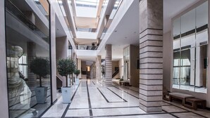 A modern interior with a central open space, glass walls, and a skylight. - Pomegranate Wellness Spa Hotel (Nea Propontida)