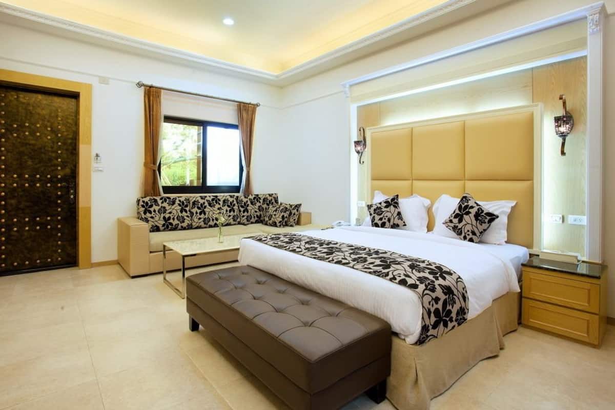 A modern bedroom with a large bed, a sofa, and a bench.