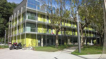 Un edificio de varios pisos con diseño moderno, que cuenta con balcones y ventanas amplias.
