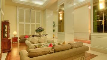 A spacious living room with a large beige sofa, a coffee table, and a fireplace.