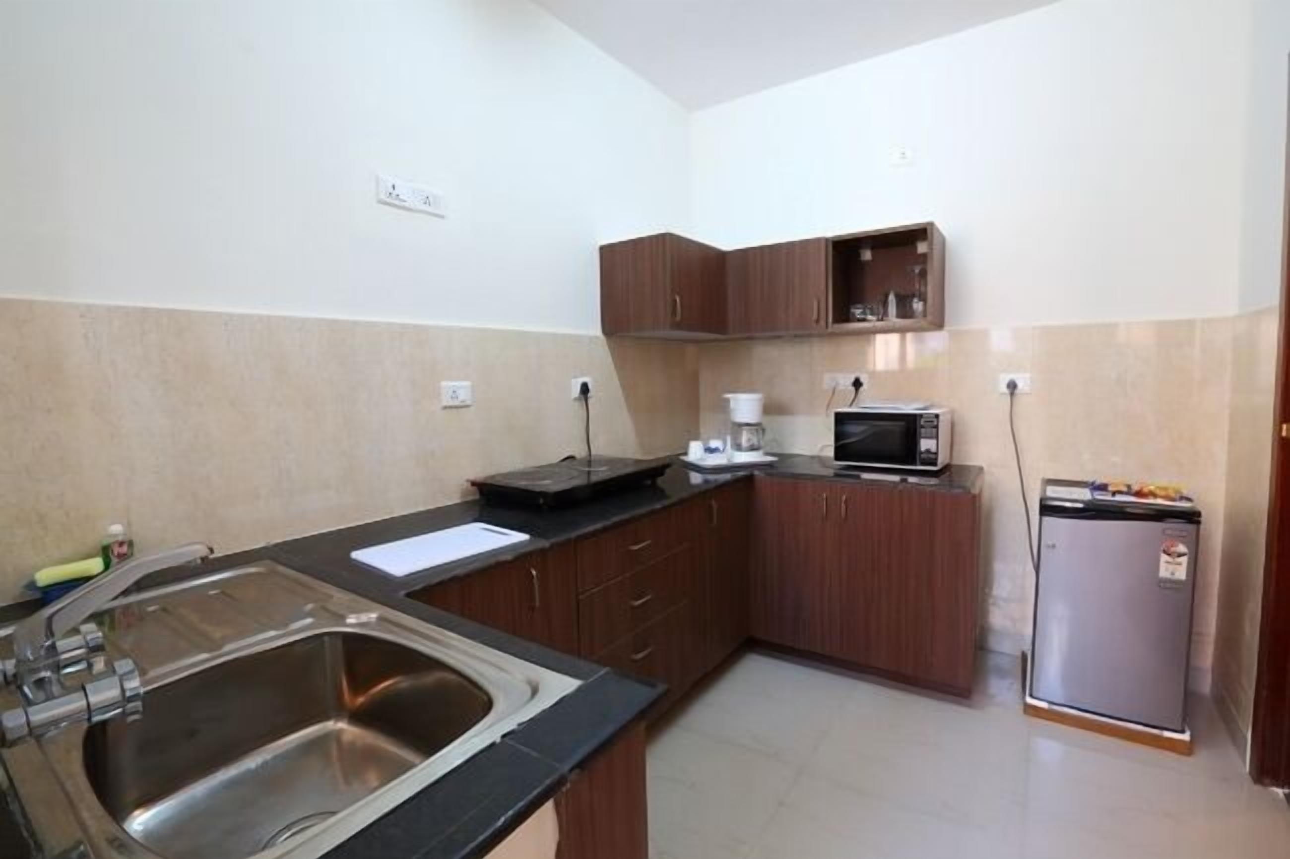A compact kitchen with a sink, microwave, and refrigerator.