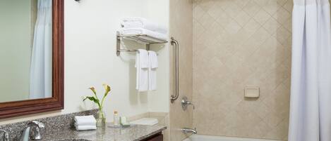 Un baño con dos lavamanos, un inodoro, una ducha y un espejo.