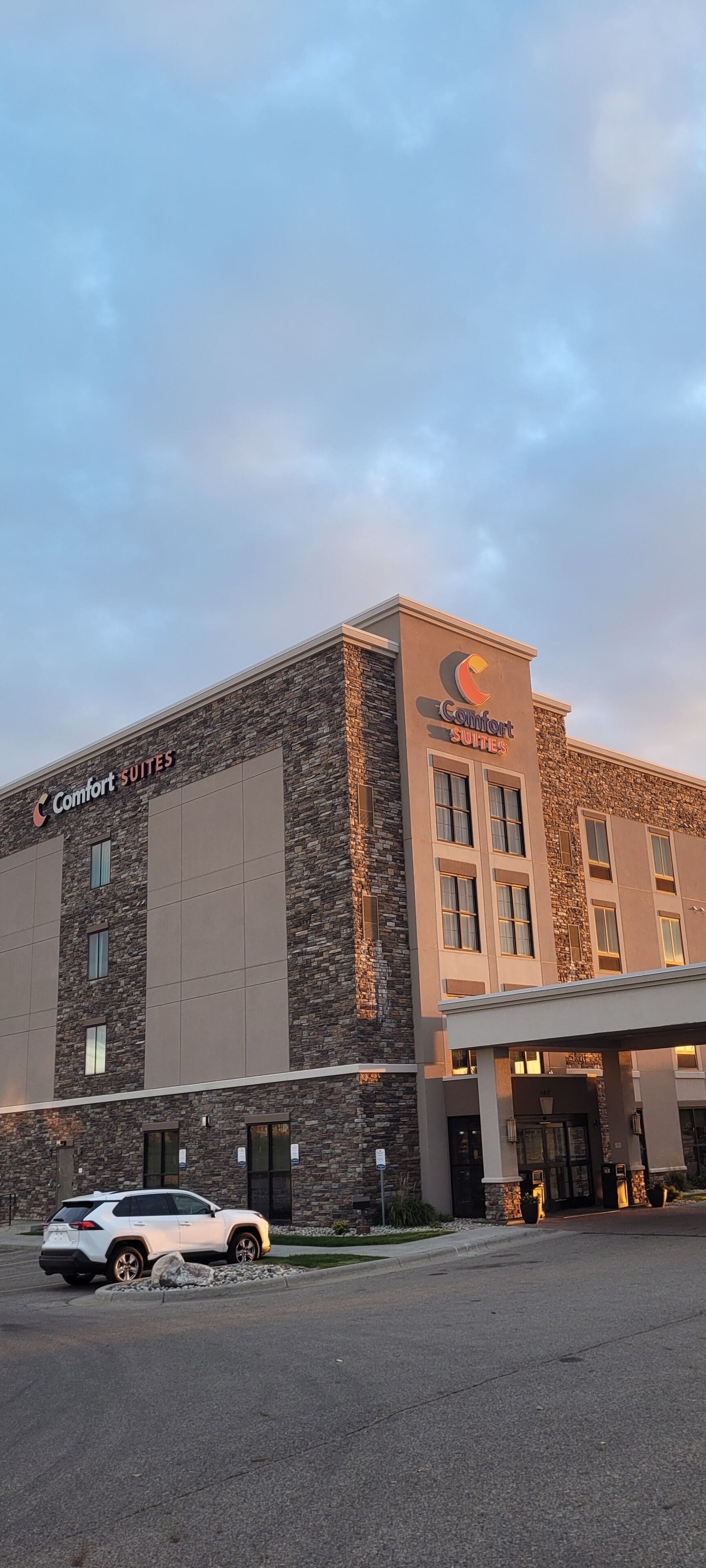 A Comfort Suites hotel with a stone facade and a modern entrance.