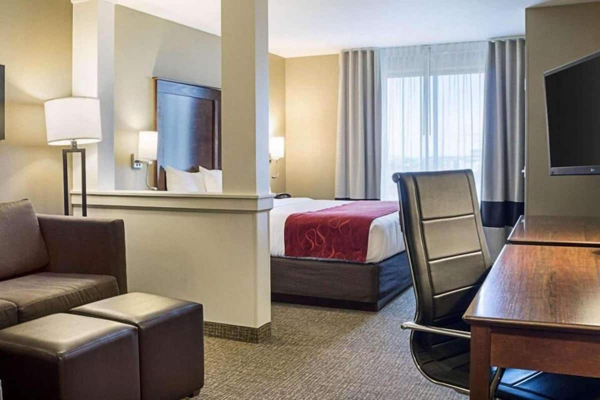 Une chambre d’hôtel équipée d’un lit, d’un bureau, d’une chaise, d’un canapé et d’une télévision.