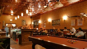 A bar with a pool table, wooden ceiling, and wall-mounted lights. - Tombstone Monument Guest Ranch (Tombstone)