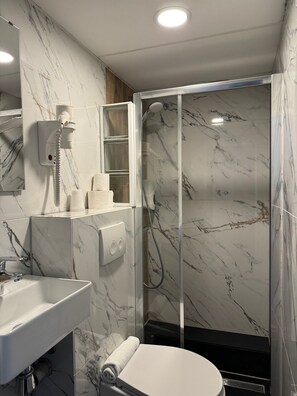 Familiekamer | Badkamer | Een douche, handdoeken