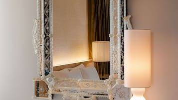 Ein Spiegel mit aufwendigen, verzierten Details und einer weißen Lampe daneben.