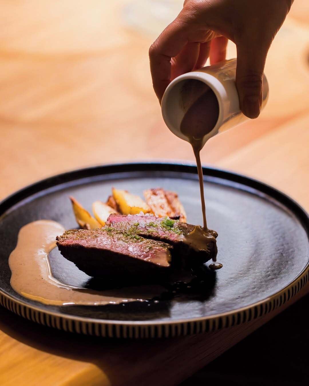 A dish with steak and fries on a plate.