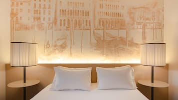Ett hotellrum med en säng, två sänglampor och en stor väggmålning.