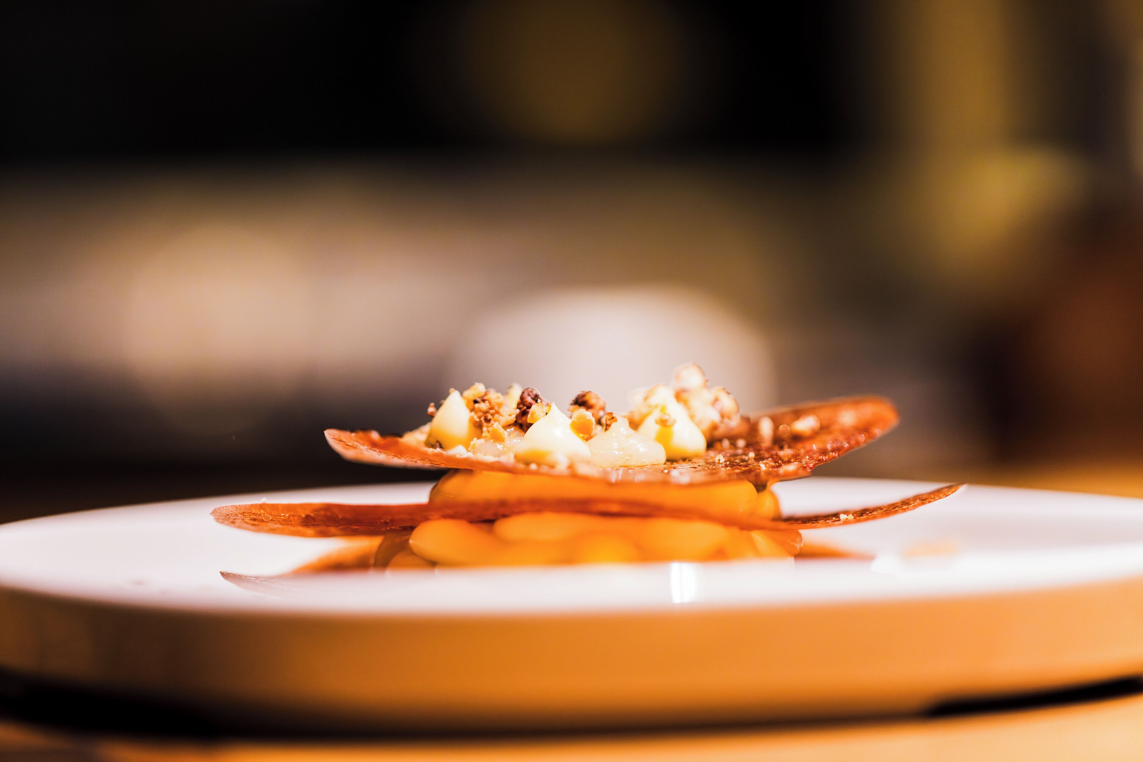 A plate with a dessert featuring caramelized bananas and nuts.