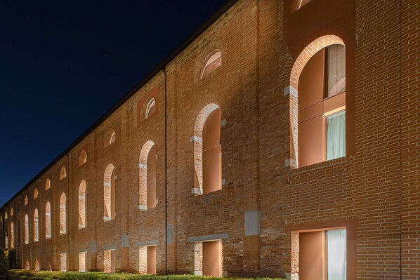 A long brick building with multiple arched windows and a flat roof.