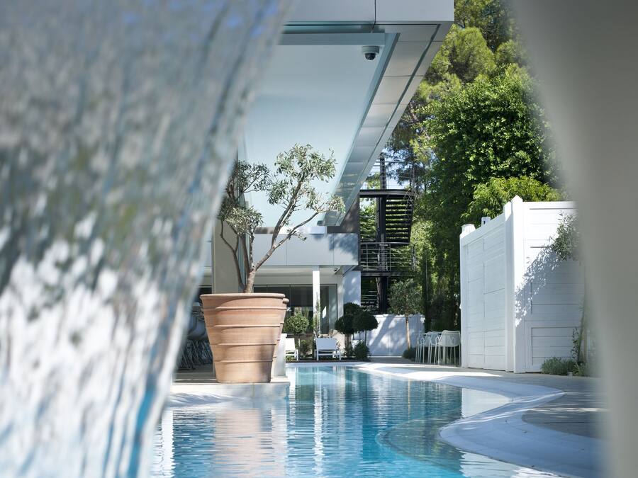 A swimming pool with a clear view of the surrounding area, including a large planter and outdoor seating.