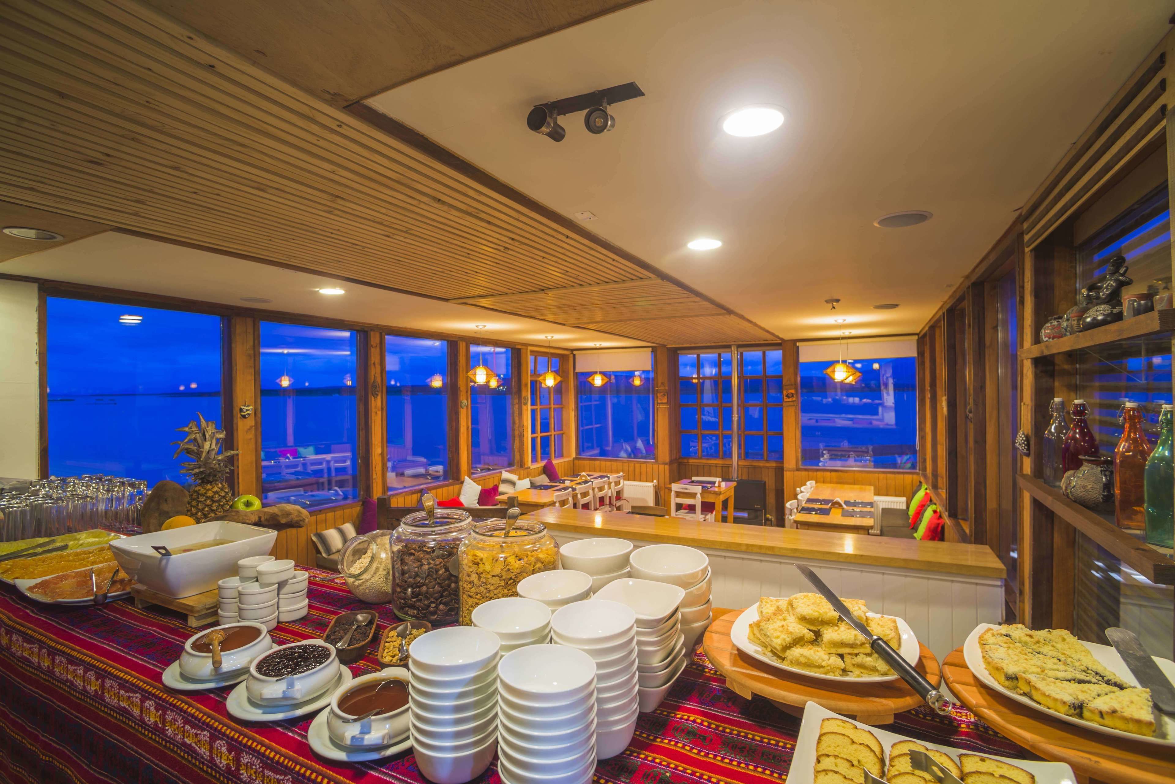 Un buffet proposant une variété de plats et de mets, un plafond en bois et de grandes fenêtres offrant une vue panoramique.