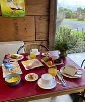Una mesa de desayuno con diferentes alimentos y un cuadro en la pared.