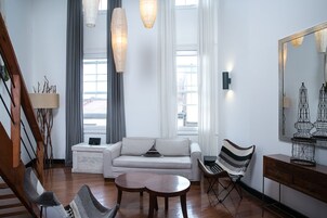 Una sala moderna con un sofá, dos sillones, una mesita de centro y un espejo.