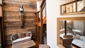 A wooden interior with a sofa, a wicker chair, and a staircase. - Casa Galos Hotel & Lofts (Valparaiso)