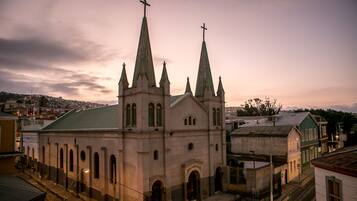A church with multiple spires and a cross on top, surrounded by buildings.