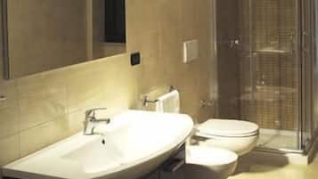 Un baño moderno con un lavamanos grande, inodoro y zona de ducha.