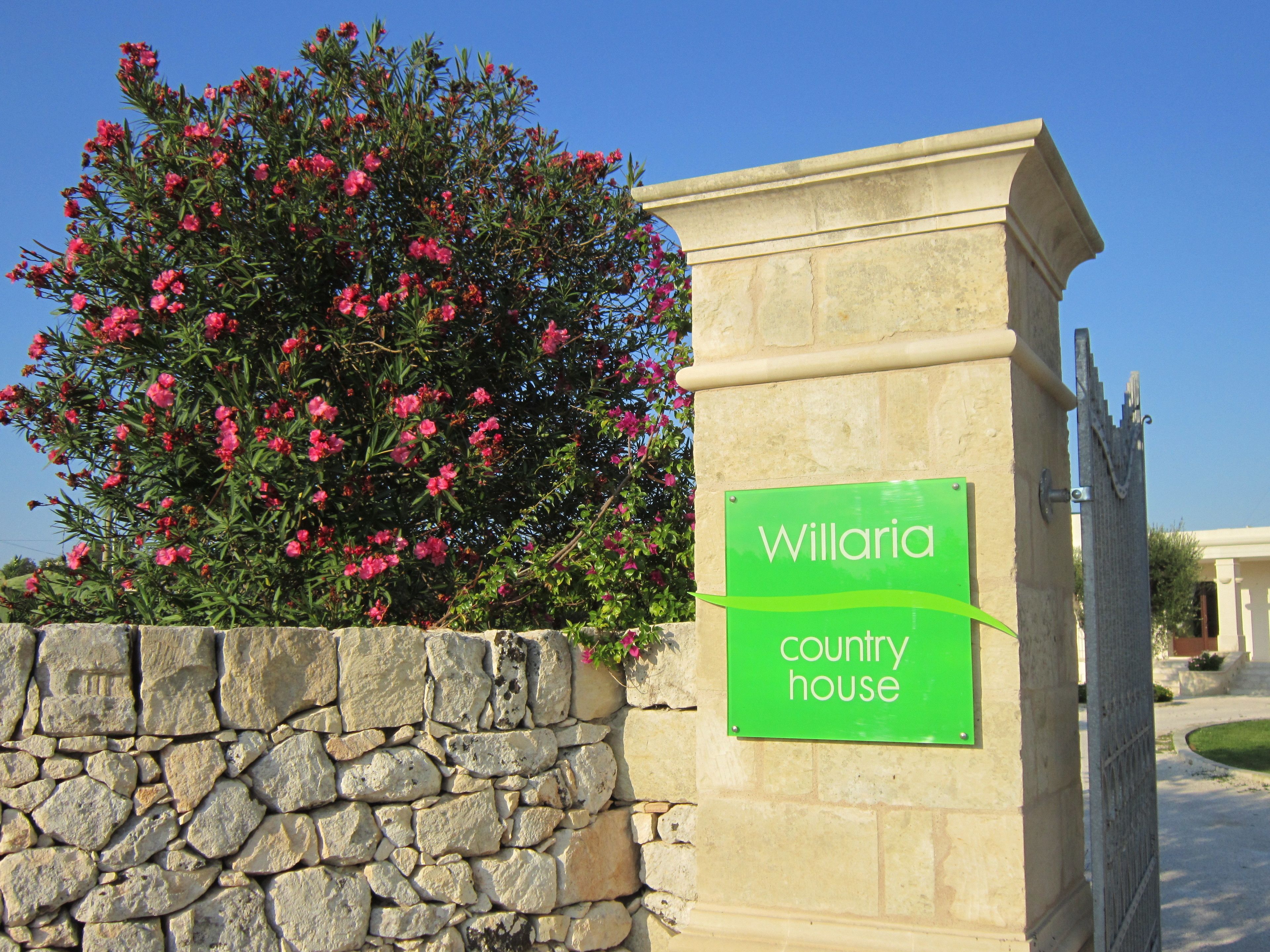 A stone wall with a sign reading "Willaria country house."