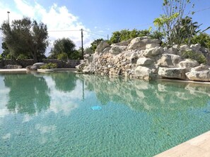 A clear pool with a stone wall and greenery in the background. - Willaria country house (Cursi)